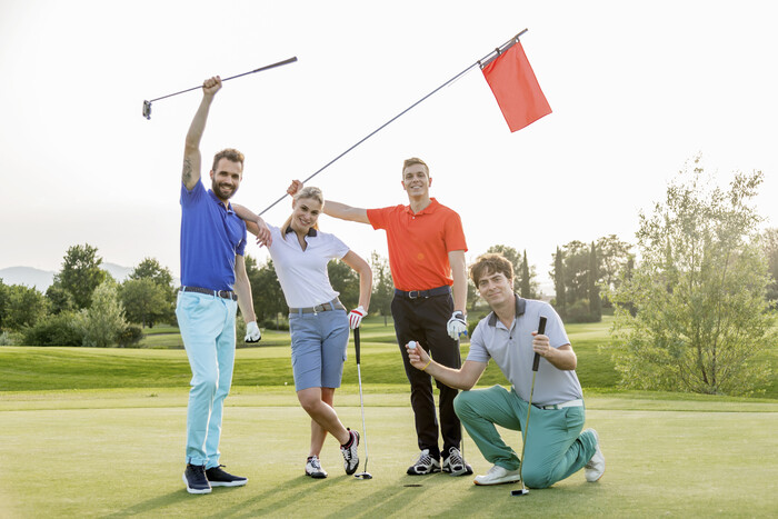 Friends celebrating a great golf shot on a sunny day